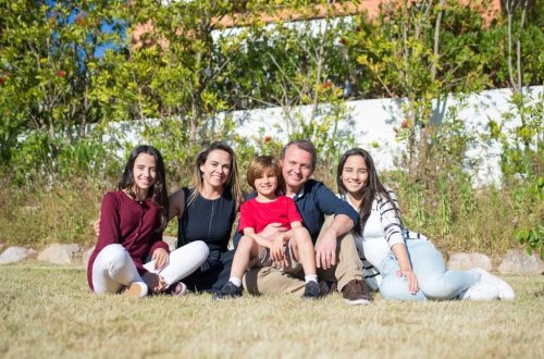 A joyful family enjoying sunny moments in a lush Portuguese garden.