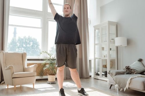 A young man enjoying a morning stretch in a bright, airy living room, embracing a healthy lifestyle.